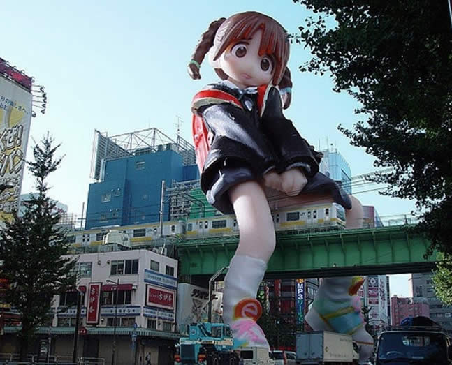 big big anime girl in city - and small train фото Огромная анимешная фигура на улице города